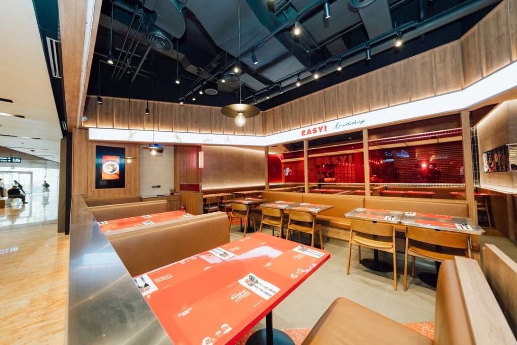 Easy Buddy dining area with layered ceiling lighting and warm booth seating