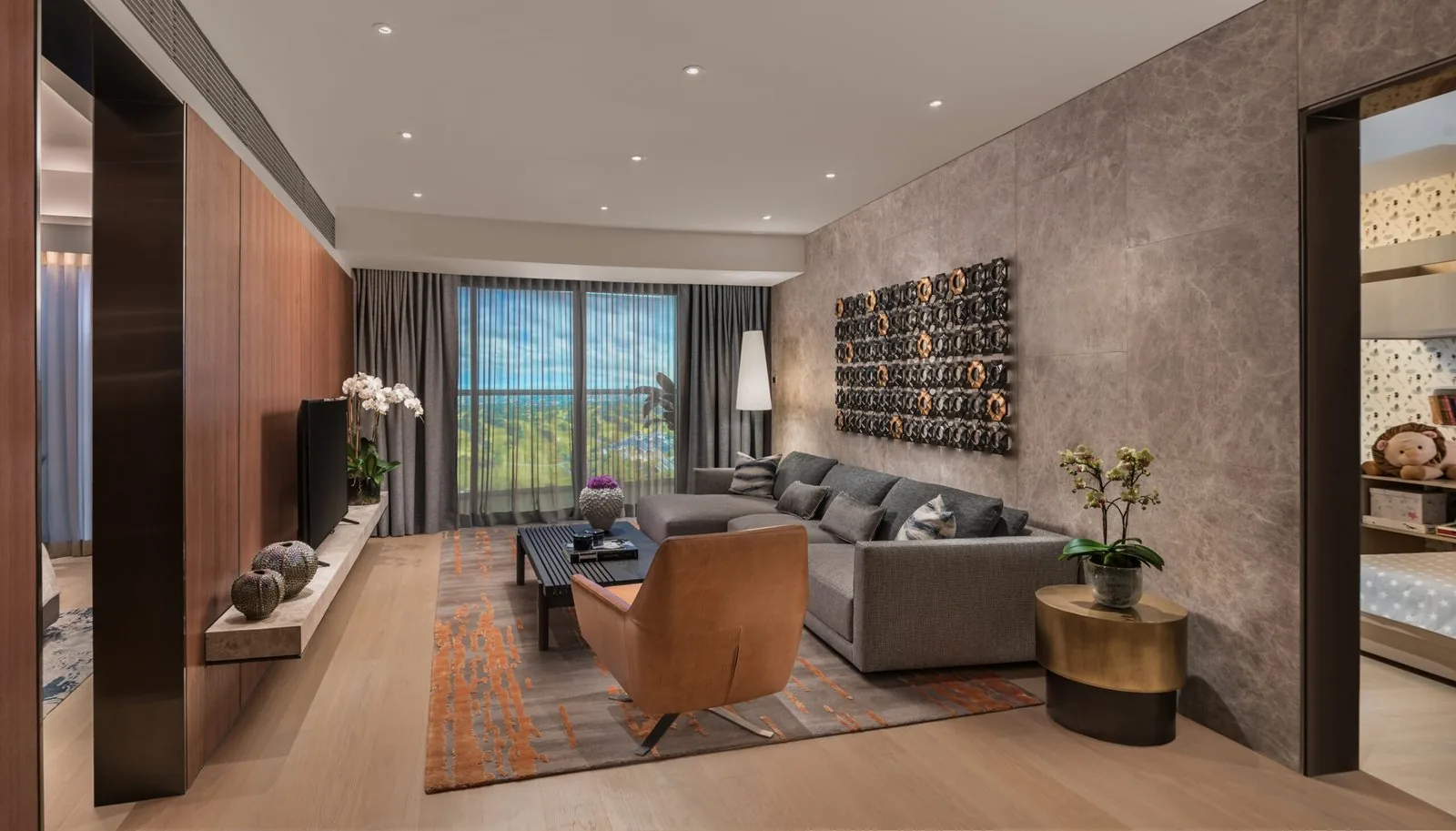 Modern high-rise condominium living room with layered warm lighting and city view