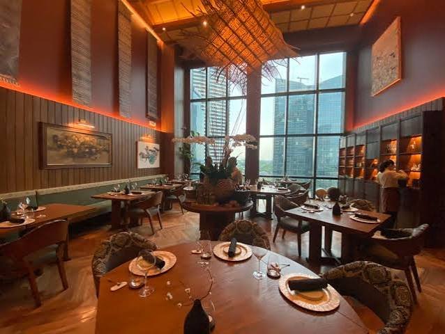 Hapag restaurant dining room with warm layered lighting and Manila skyline view