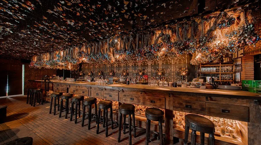 The Iron Fairies Manila bar beneath a warm-lit canopy of butterflies