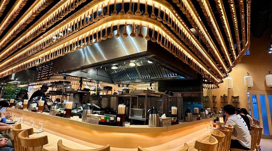 Mendokoro Ramenba open kitchen framed by warm ceiling lighting